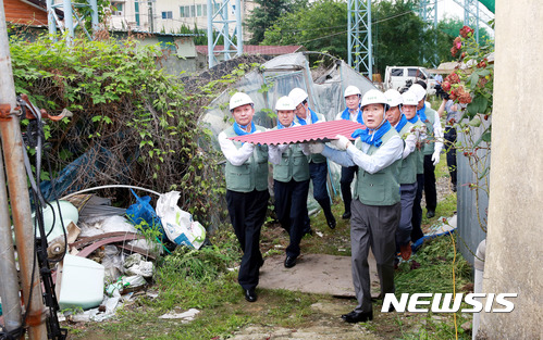 【창원=뉴시스】 홍정명 기자 = 6일 경남 창원시 진해구 용원동에서 경남농협 이구환(왼쪽 첫 번째) 경남본부장, 김성찬(오른쪽 첫 번째) 국회의원 등이 사랑의 집 고치기에 사용될 건축 자재를 운반하고 있다.2017.07.06.(사진=경남농협 제공) photo@newsis.com