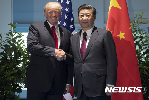  【함부르크(독일)=AP/뉴시스】도널드 트럼프 미 대통령(왼쪽)과 시진핑(習近平) 중국 국가주석이 8일 독일 함부르크에서 회담을 시작하기 전 악수하고 있다. 2017.7.9 