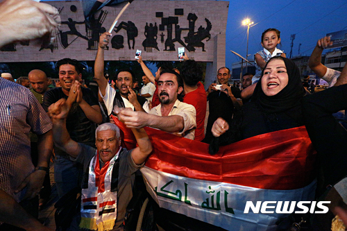 【바그다드=AP/뉴시스】 7월9일 이라크 수도 바그다드 타흐리르 광장에서 시민들이 이라크군의 모술 탈환 선언에 환호하고 있다. .2017.07.10