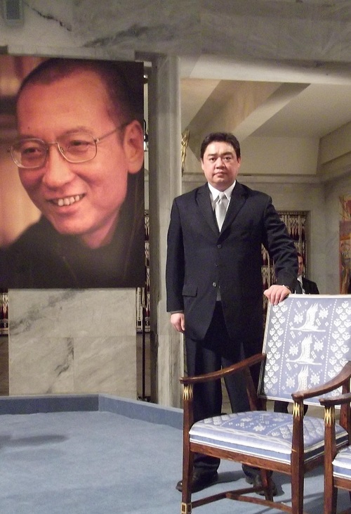 1989년 중국 톈안먼 민주 운동 학생 리더 중 한명이 였던 우얼카이시가 지난 2010년 12월10일 자신의 스승이자 친구이자 '가족'인 류샤오보가 앉아보지 못한 노벨평화상 빈의자 옆에서 사진을 찍고 있다. 사진출처: 우얼카이시 블로그 