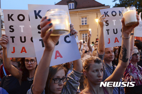 【바르샤바(폴란드) = AP/뉴시스】 폴란드 전국에서 반정부 시위가 일어나고 있는 가운데 22일(현지시간) 바르샤바 광장의 시위대가 헌법수호를 의미하는 "헌법"의 플래카드를 들고 정부 여당의 사법부 장악 시도에 반대하는 시위에 나섰다.2017.07.23 