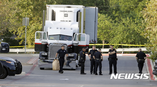 【샌안토니오=AP/뉴시스】미 텍사스주 접경도시에서 23일 아침 밤중에 8명이 뒤칸에서 숨진 채 발견된 트랙터-트레일러를 경찰들이 조사하고 있다. 트럭은 월마트 주차장에 세워져 있었다. 2017. 7. 23. 