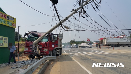 【울산=뉴시스】박일호 기자 = 24일 오전 9시45분께 울산시 울주군 온양읍 외고산옹기마을 입구 도로에서 25t 덤프트럭이 전봇대를 들이받는 사고가 발생했다. 2017.07.24. (사진=울산소방본부 제공) photo@newsis.com