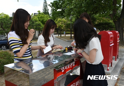 【경주=뉴시스】강진구 기자 = 경상북도관광공사(사장 김대유)는 보문관광단지 느린우체통 이용객이 1만6000명을 돌파했다고 24일 밝혔다.사진은 지난 주말 보문단지를 찾은 관광객들이 느린우편엽서를 쓰고 있다.2017.07.24.(사진=경상북도관광공사 제공) photo@newsis.com