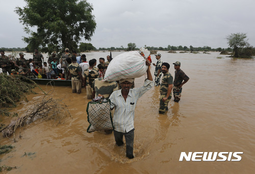 【타라=AP/뉴시스】 몬순 장맛비가 계속된 인도 서부 구자라트주의 바나스칸타 지역에서 26일 군인들이 홍수 이재민들을 구조하고 있다. 이 주에서만 이번 주에 29명이 사망했다. 2017. 7. 26.