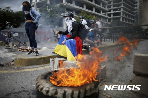 【카라카스(베네수엘라)=AP/뉴시스】니콜라스 마두로 베네수엘라 대통령 에 반대하는 시위대가 4일 수도 카라카스에서 타이어에 불을 붙여 바리케이드를 설치한 채 제헌의회 출범에 항의하고 있다. 베네수엘라군은 4일 마두로 대통령을 강력하게 비난해온 루이사 오르테가 검찰총장의 사무실을 포위, 오르테가 해임이 임박했음을 알렸다. 2017.8.5