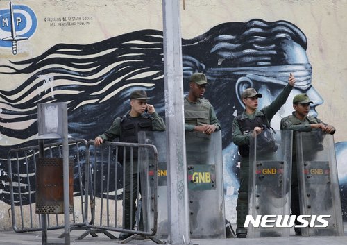 【카라카스( 베네수엘라) = AP/뉴시스】 = 베네수엘라 수도 카라카스의 검찰청을 포위한 볼리바르 보안군이 8월 5일(현지시간) 새 검찰총장의 선서가 새로 선출된 제헌의회에서 진행되는 동안 루이사 오르테가 검찰총장의 진입을 막고 있다.     