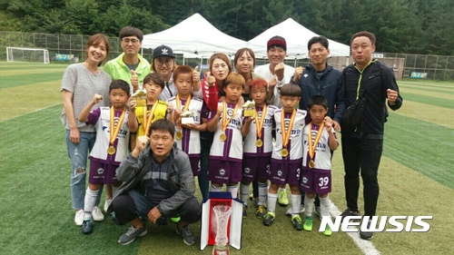 【태백=뉴시스】김태식 기자 = 13일 태백 축구전용 구장에서 ‘2017 태백 리틀 챔피언스 디비전컵 축구대회’가 열리고 있는 가운데 U－8세부에서 우승한 포항 원동초등학교 선수들과 정태원 감독, 학부모들이 기념촬영을 하고 있다.2017.08.13.(사진=독자 제공) photo＠newsis.com