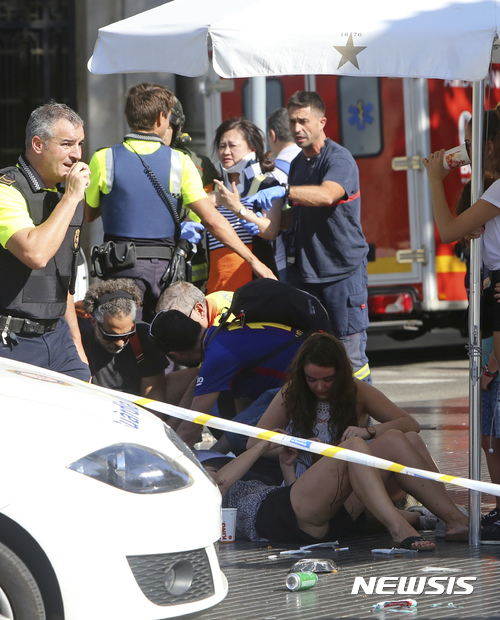 【 바르셀로나=AP/뉴시스】스페인 바르셀로나에서 17일(현지시간) 경찰과 구급요원들이 차량 돌진 테러로 다른 사람들을 돌보고 있다.  2017.08.18 