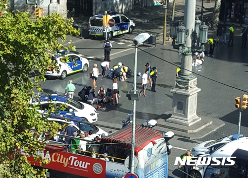 【 바르셀로나=AP/뉴시스】스페인 바르셀로나에서 17일(현지시간) 차량 돌진 테러가 발생한 직후 사람들이 쓰러져 있는 부상자를 돌보고 있다. 2017.08.18 