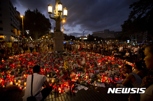 【바르셀로나( 스페인) = AP/뉴시스】 스페인 바르셀로나에서 20일(현지시간) 추모객들이 꽃과 촛불을 바치며 차량테러 희생자들과 부상자들을 위해 기도하고 있다. 2017.08.21      