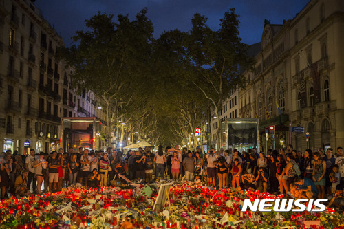 【바르셀로나( 스페인) = AP/뉴시스】 = 바르셀로나 차량 테러 현장에 모여든 주말 추모객들이 꽃과 촛불을 바치며 희생자들과 부상자들을 위해 기도하고 있다.   