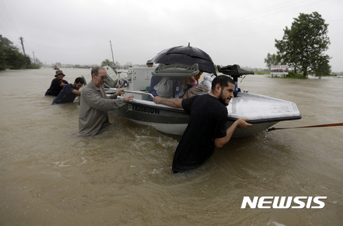 【휴스턴=AP/뉴시스】허리케인 하비의 영향으로 폭우가 내려 대홍수가 발생한 미국 텍사스주 휴스턴에서 28일(현지시간) 주민들이 배를 잡고 대피하고 있다. 2017.08.29 