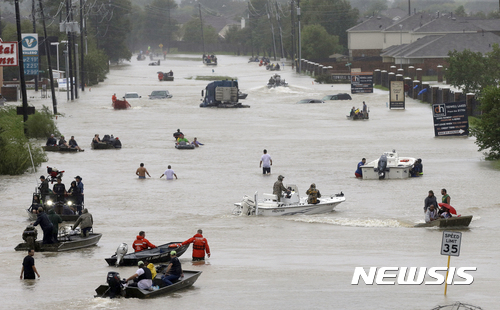 【휴스턴=AP/뉴시스】28일(현지시간) 미국 휴스턴 샘휴스턴 지역에서 주민들과 구조보트가 홍수로 인해 물로 가득찬 거리를 지나가고 있다. 미 기상당국은 오는 31일까지 텍사스와 루이지애나주 일대에 500㎜의 비가 추가로 올 것으로 예보했다. 2017.08.29 