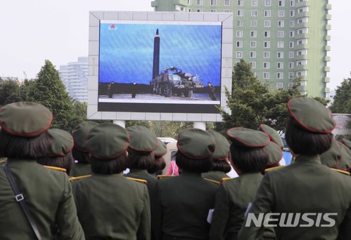 【AP/뉴시스】 = 지난 8월 30일 북한의 대륙간 탄도미사일 화성12호가 발사되었을 때 평양 중앙역 광장에서 사람들이 대형 TV화면을 통해 이 뉴스를 지켜보고 있다.   