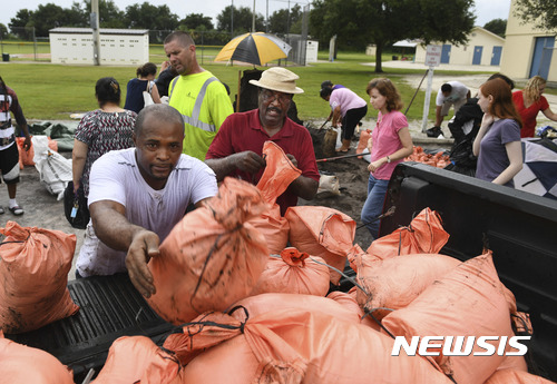 James Byrd, left, and Richard Clark, right, load their sandbags in a truck Wednesday, Sept. 6, 2017, at Newtown Estates Recreation Center in Sarasota, Fla., as they prepare for Hurricane Irma. The each got their ten bags before Sarasota County ran out of sandbags for residents. The county still has plenty of dirt but residents must bring and fill their own bags. A new shipment of sandbags is expected Thursday. (Mike Lang/Sarasota Herald-Tribune via AP) 