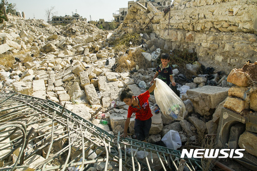 【알레포( 시리아) = AP/뉴시스】 =  폭격으로 거의 폐허가 되다시피한 시리아 동부의 알레포 시내에서 9월 12일 어린이들이 재활용품을  모으고 있다. 7년째 내전을 겪은 이 곳은 최근 정부군에 의해 탈환되었지만 도시는 거의 다 파괴되었다.    