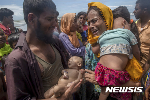 【샤 포리르 드윕=AP/뉴시스】미얀마 로힝야 난민 부부가 14일 배를 타고 방글라데시로 넘어오려다 배가 전복되면서 익사한 아기를 내려다 보며 통곡하고 있다. 2017.09.15