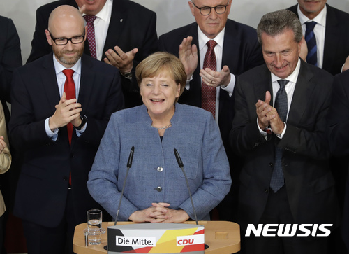 【베를린=AP/뉴시스】 24일(현지시간) 실시된 총선거에서 4연임에 성공한 앙겔라 메르켈(가운데) 총리가 독일 베를린에서 총선 결과에 대한 입장을 밝히면서 웃고 있다. 2017.09.25.