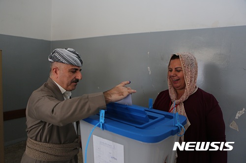 【에르빌=AP/뉴시스】 쿠르드족 남녀가 25일 이라크 에르빌시에서 열린 분리독립 주민투표에 참여해 투표용지를 투표함에 넣고 있다. 2017.09.25.
