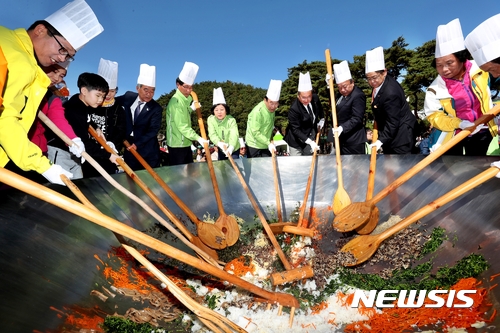 【보은=뉴시스】이성기 기자 = 지난 21일 충북 보은 속리산 잔디공원에서 보은지역 기관단체장 등이 속리산 천왕봉의 높이를 상징하는 1058명 분의 산채비빔밥을 비비고 있다. 이 비빔밥은 속리축전 행사에 참여한 관광객 등에게 무료로 제공됐다.2017.10.22(사진=보은군 제공) sklee@newsis.com 