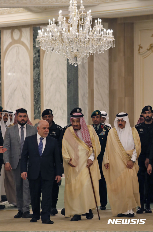 【리야드=AP/뉴시스】 사우디아라비아의 살만 국왕(가운데)과 이라크의 하이데르 알아바디 총리가 22일 사우디 수도에서 열린 양국 협력위원회 출범식 식장으로 걸어가고 있다. 이 행사에 미국의 렉스 틸러슨 국무장관이 참석했다. 2017. 10. 22. 