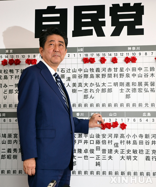 【도쿄=신화/뉴시스】아베 신조 일본 총리가 22일 도쿄 자민당 당사에서 중의원 선거 당선자 이름에 붉은 색 꽃을 붙이고 있다. 2017.10.23 