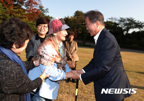 【서울=뉴시스】문재인 대통령이 23일 오후 청와대 녹지원을 관람중인 이효재 경신사회복지연구소 소장을 만나 손을 잡고 인사하고 있다. 2017.10.23. (사진=청와대 제공)  photo@newsis.com 