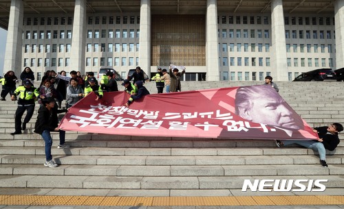 【서울=뉴시스】조성봉 기자 = 트럼프 미국 대통령 방한을 나흘 앞둔 3일 오후 서울 영등포구 여의도 국회 본청 계단에서 트럼프 방한을 반대하는 대학생들 30여명이 '전쟁막말 트럼프는 국회연설 할수 없다' 고 적힌 대형 플래카드를 들고 기습시위를 하고 있다. 2017.11.03.suncho21@newsis.com