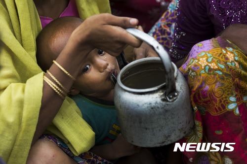 【팔롱 카일(방글라데시)=AP/뉴시스】2일 방글라데시 팔롱 카일 인근 로힝야 난민수용소에 들어가기 위해 국경을 따라 기다리던 어린 아이가 물을 마시고 있다. 눈가에 눈물이 흐르고 있다. 2017.11.07