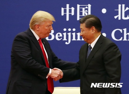 【베이징=AP/뉴시스】도널드 트럼프 미국 대통령과 시진핑 중국 국가주석이 9일 베이징 인민대회당에서 미중 기업들 간의 협약식에 참석해 악수하고 있다. 2018.11.09