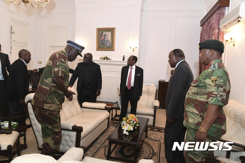 【하라레(짐바브웨)=AP/뉴시스】로버트 무가베(93) 짐바브웨 대통령(가운데)이 19일(현지시간) 수도 하라레에 위치한 의회 의사당에서 군사 관계자들과 회동하고 있다. 이날 집권여당은 무가베 대통령을 당 대표직에서 해임하고 오는 20일까지 사퇴하지 않으면 탄핵 절차에 들어갈 것임을 최후통첩했다. 이후 무가베 대통령은 몇 시간 만에 사퇴 의사를 밝혔다. 2017.11.20.