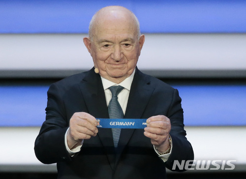 Former Russian soccer player Nikita Simonyan holds up the team name of Germany at the 2018 soccer World Cup draw in the Kremlin in Moscow, Friday, Dec. 1, 2017. (AP Photo/Ivan Sekretarev)