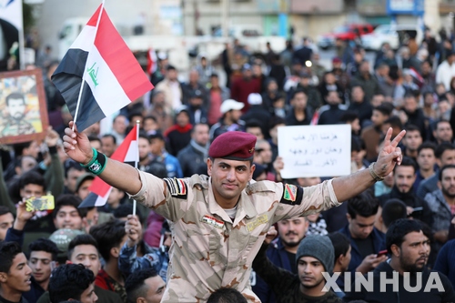 【바그다드(이라크)=신화/뉴시스】 지난 해 12월 이라크 정부가 극단주의 무장세력 IS에 대한 승리를 선포한 뒤 바그다드시내 광장에 모여서 승전을 축하하는 이라크 군과 시민들.    