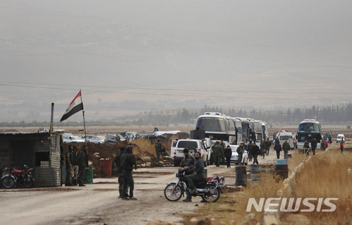 【다라=AP/뉴시스】시리아 군이 수도 남서부 요충지 ‘서구타(Western Ghouta)’에서 반군 조직을 몰아냈다. 29일(현지시간) 남부 다라 지역의 검문소에서 정부군들이 반군 조직원과 그 가족이 탄 버스를 인근에 머물러 있다. 2017.12.30