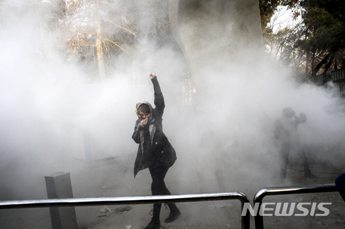 【 테헤란(이란) = AP/뉴시스】 지난 해 12월 30일 테헤란 대학에서 한 대학생이 최루탄을 발사하는 이란 대테러 경찰부대를 향해 항의의 구호를 외치고 있다( 제보자 사진).  