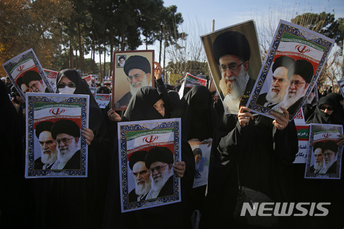 【콤=AP/뉴시스】3일(현지시간) 이란 콤에서 친정부 시위대가 아야톨라 알리 하메네이 이란 최고지도자의 사진을 들고 모여 있다. 2018.1.4.