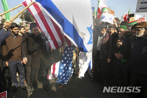 【마슈하드=AP/뉴시스】4일(혀지시간) 이란 북동부 마슈하드에서 친정부 시위대가 성조기와 이스라엘 국기를 불태우고 있다. 사진은 이란 타스님 뉴스통신 제공. 2018.1.5. 