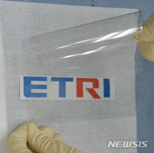 【대전=뉴시스】 2차원 나노시트가 코팅된 플라스틱 필름. ETRI 로고가 선명히 보일 만큼 투명하고 유연하다.