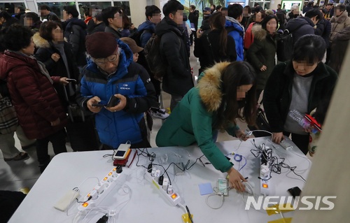 【제주=뉴시스】우장호 기자 = 제주 지역에 매서운 한파가 몰아친 12일 제주국제공항 체류객들이 스마트폰 무료충전소 앞에서 자신의 순서를 기다리고 있다. 이날 제주공항에는 한국공항공사 추산 3000여명의 체류객에 공항 내에 머물렀다. 2018.01.11.woo1223@newsis.com