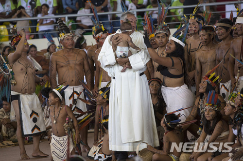 【푸에르토말도나도(페루)=AP/뉴시스】아마존 원주민들이 19일(현지시간)페루의 푸에르토말도나도에서 어린아이를 안은 한 신부와 함께 페루를 방문한 프란치스코 교황이 도착하기를 기다리고 있다. 프란치스코 교황은 이날 "지구의 허파" 아마존 열대우림을 보호해야 한다며 아마존 개발을 중단할 것을 촉구했다. 2018.1.20