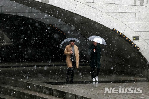 【서울=뉴시스】고범준 기자 = 눈과 비가 내리는 22일 오후 서울 청계천에서 시민들이 우산을 쓰고 지나가고 있다. 2018.01.22. bjko@newsis.com