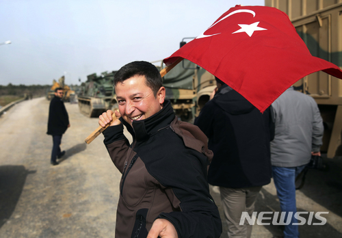 【수게디기=AP/뉴시스】터키와 시리아 접경인 수게디기에서 한 남성이 터키군의 시리아 쿠르드 민병대 소탕 작전을 응원한다며 국기를 흔들고 있다. .2018.1.23.