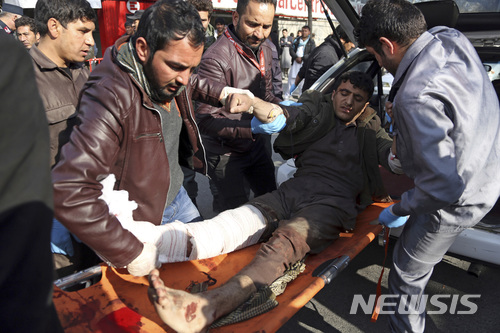 【카불(아프가니스탄)=AP/뉴시스】자살폭탄차량 테러가 발생한 아프가니스탄 수도 카불 중심가의 사고 현장에서 시민들이 부상자를 들것에 실어 나르고 있다.  2018.1.27