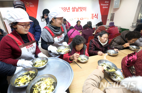 【창원=뉴시스】 홍정명 기자 = 6일 경남 창원시 의창구 의창복지회관에서 BNK경남은행 손교덕 은행장 부인 송혜경 여사와 BNK경남은행 임원부인회, 본점 봉사단 관계자들이 지역 어르신들에게 ‘설맞이 사랑의 떡국'을 배식하고 있다.2018.02.06.(사진=BNK경남은행 제공) photo@newsis.com