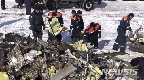 【모스크바 = AP/뉴시스】 지난 달  13일 발생한 모스크바 도모데도보 공항부근의 항공기 추락사고 현장에서 구조대원들이 AN-148  항공기 잔해를 조사하고 있다.     