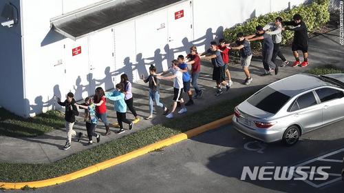 【서울=뉴시스】 미국에서 또 총기 난사 사건이 발생해 최소한 17명이 숨졌다. CNN방송 등의 보도에 따르면 이날 플로리다 주 남쪽 브로워드 카운티의 파크랜드에 있는  마저리 스톤맨 더글러스 고교(Marjory Stoneman Douglas High School)에서 수업 종료 직전 10대 한 명이 반자동 소총인 AR-15를 마구 난사했다. 경찰은 이 학교에 다니다가 교칙 위반으로 퇴학당한 니콜라스 크루스(19)를 총격 용의자로 체포했다. 사진은 총격 사건으로 마저리 스톤맨 더글러스 고교학생들이 학교 밖으로 피시하는 모습. <출처: CNN방송> 2018.02.15.