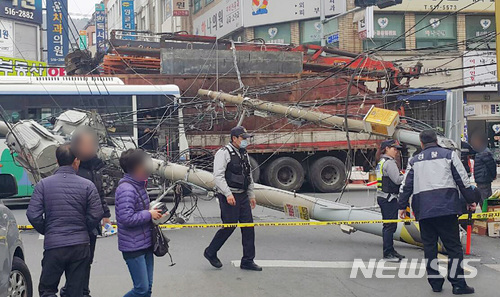 【부산=뉴시스】 하경민 기자 = 19일 오후 2시 32분께 부산 금정구 부곡시장 사거리에서 건설현장 고철을 싣고 가던 22t 트럭의 적재물이 전선이 걸리는 바람에 전신주 2개가 쓰러지는 사고가 났다. 2018.02.19. (사진=부산경찰청 제공) yulnetphoto@newsis.com 