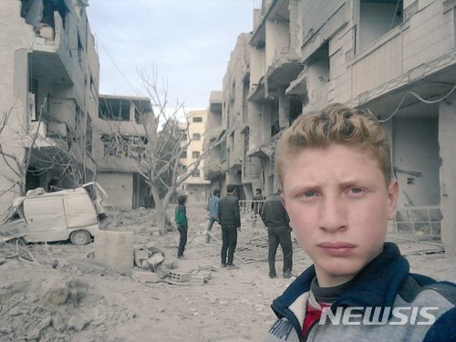 【서울=뉴시스】시리아 동구타에 사는 15세 소년 무함마드 나젬이 트위터, 유튜브 등을 통해 공습으로 망가진 동구타의 모습을 전달하고 있다. <출처 :트위터> 2018.2.22.
