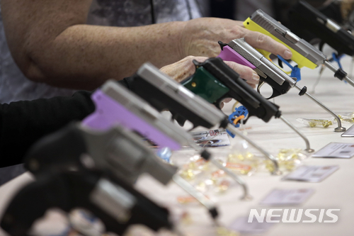[인디애나폴리스(미 인디애나주)=AP/뉴시스]2014년 4월25일 미 인디애나주 인디애나폴리스에서 열린 전미총기협회(NRA) 연례총회에 참가한 사람들이 전시된 권총들을 살펴보고 있다. 2018.2.27